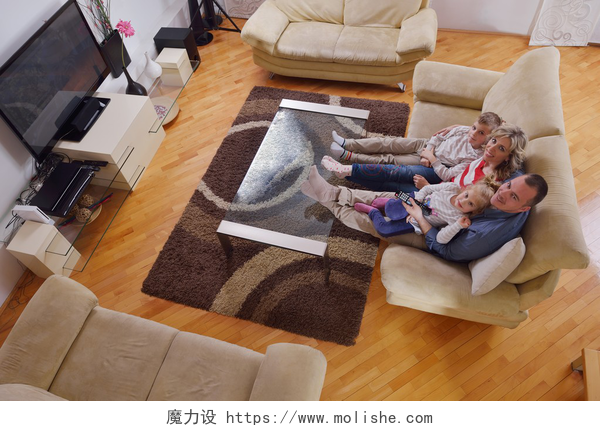 幸福的一家人坐在沙发上闲聊快乐的家庭在家里看电视